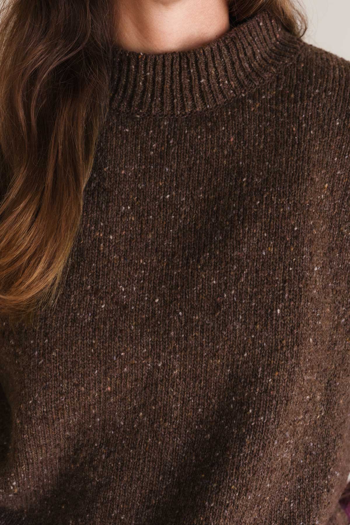 Brown knitted sweater with a textured pattern.