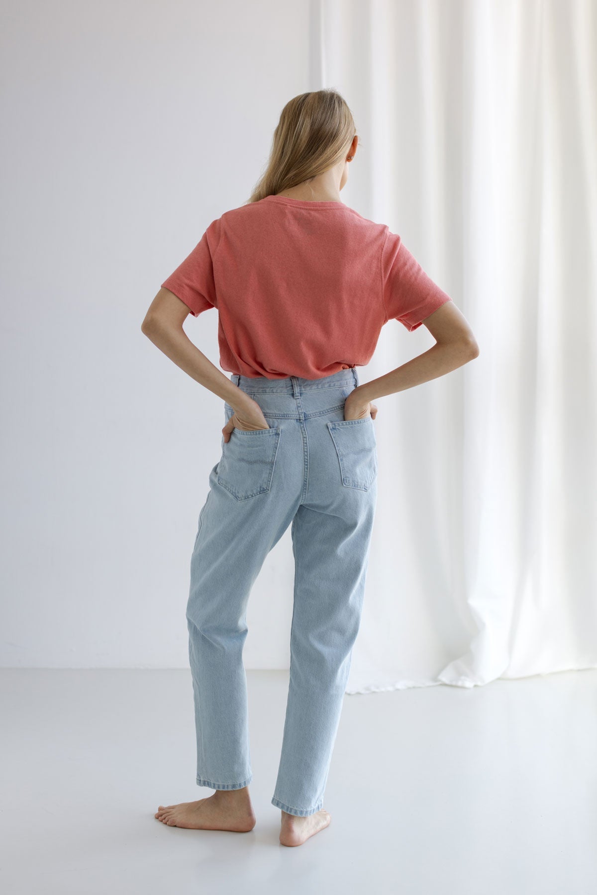 Pink roundneck top women light blue jeans full body view back