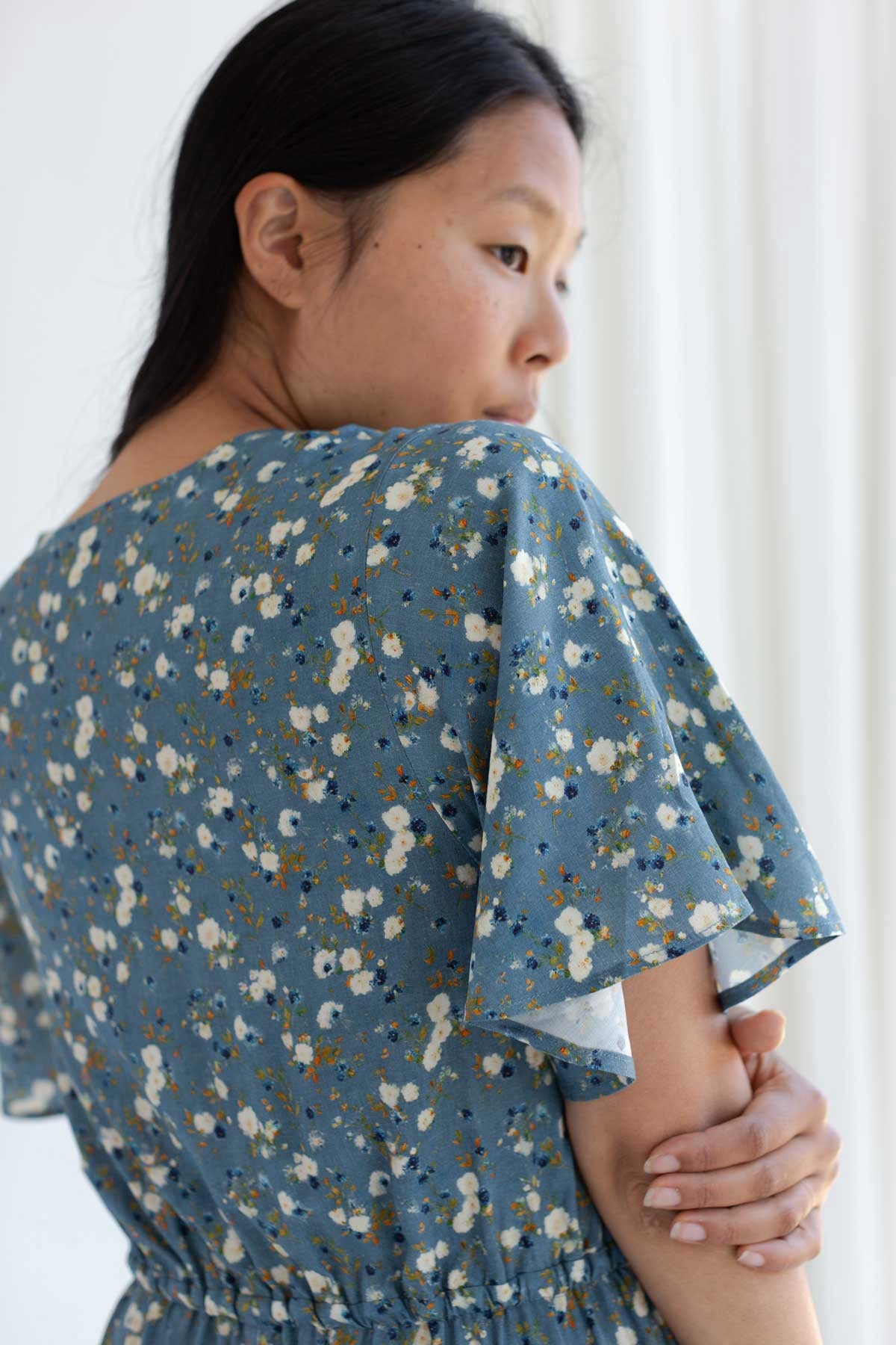 Close-up back shoulder view of a blue floral-print midi dress.