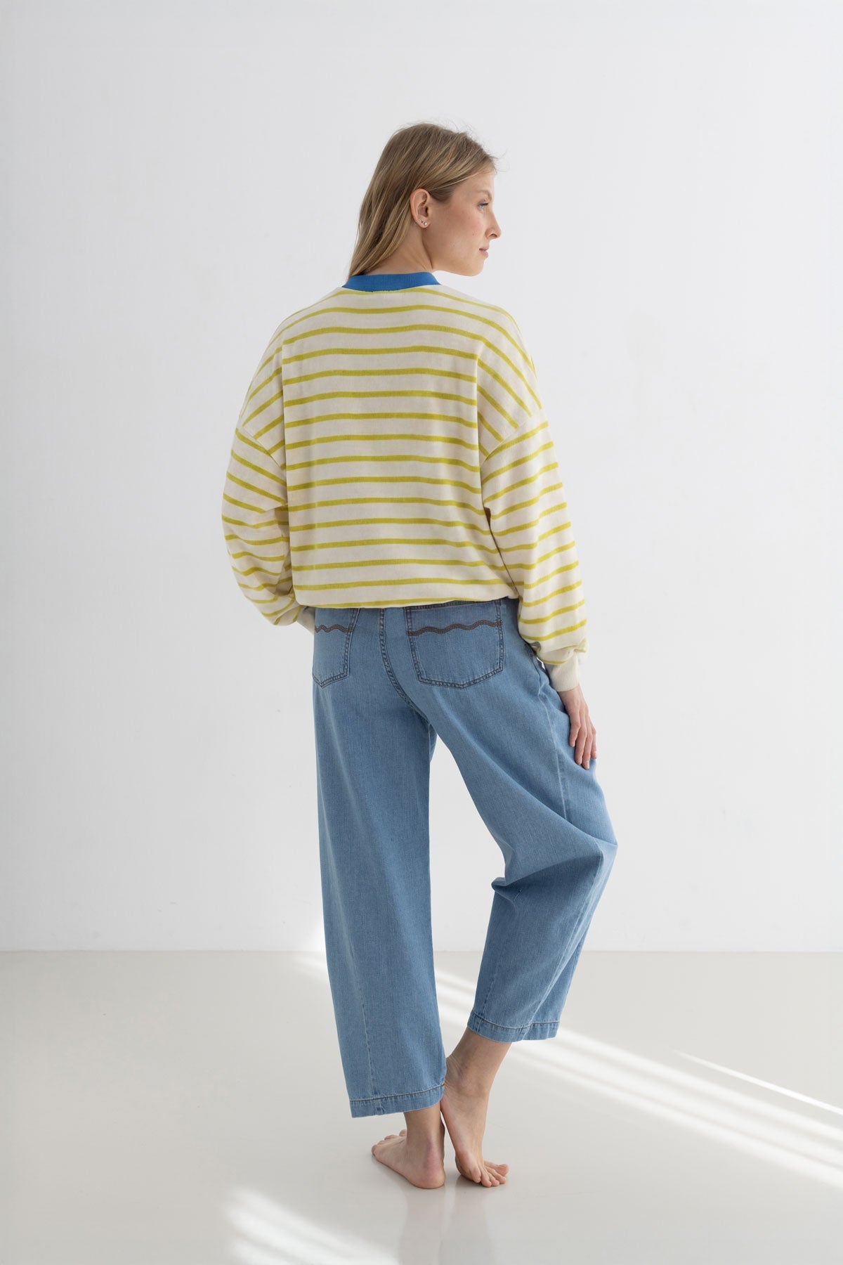 Golden green striped sweatshirt women denim trouser full body view women back