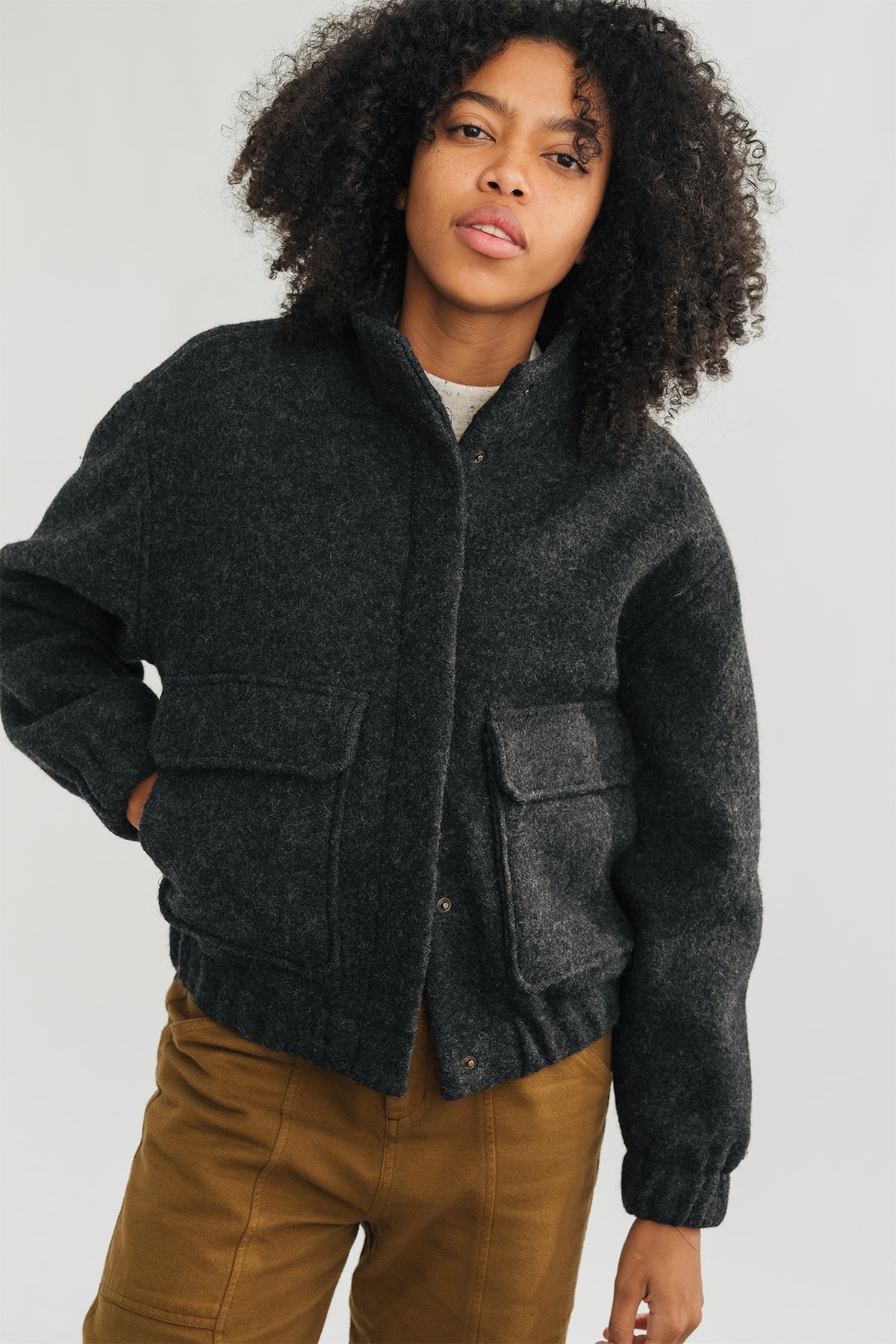meta-hover, model wearing grey jacket in boiled wool with front pockets.