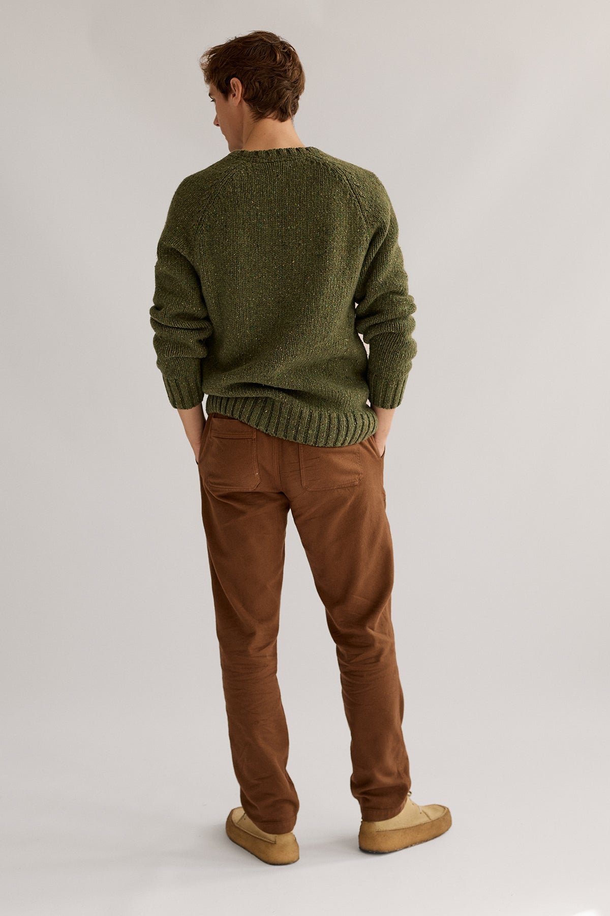 Man wearing green sustainable knit with colorful neps