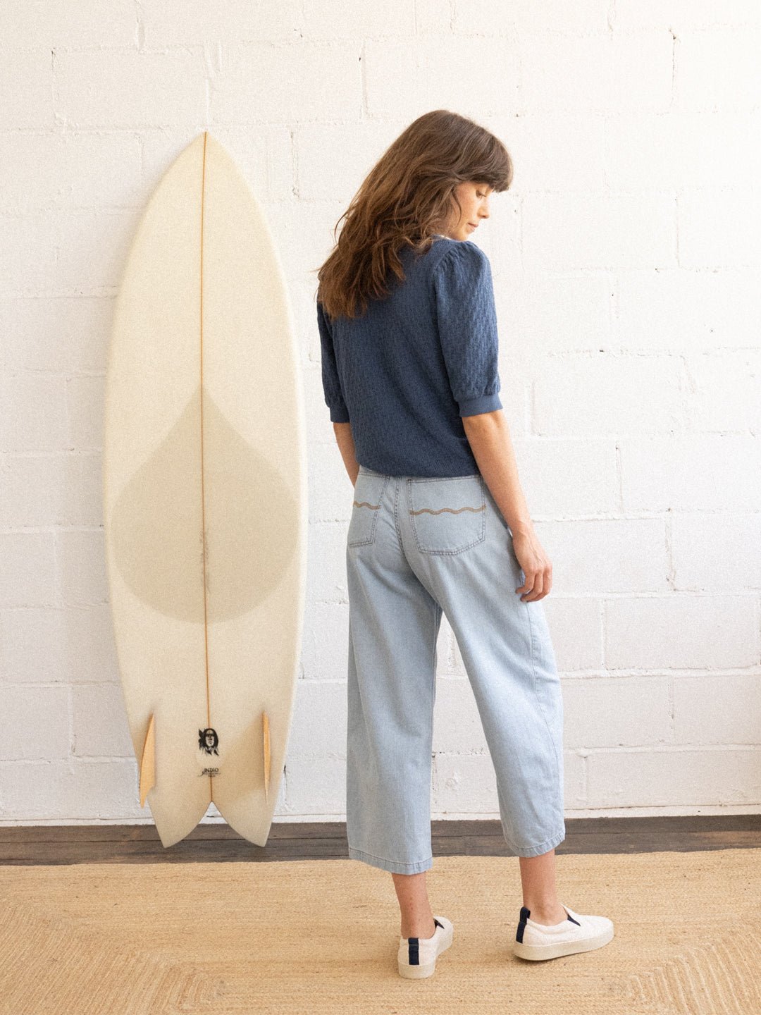 blue organic cotton denim pants featuring wave-embroidered back pockets