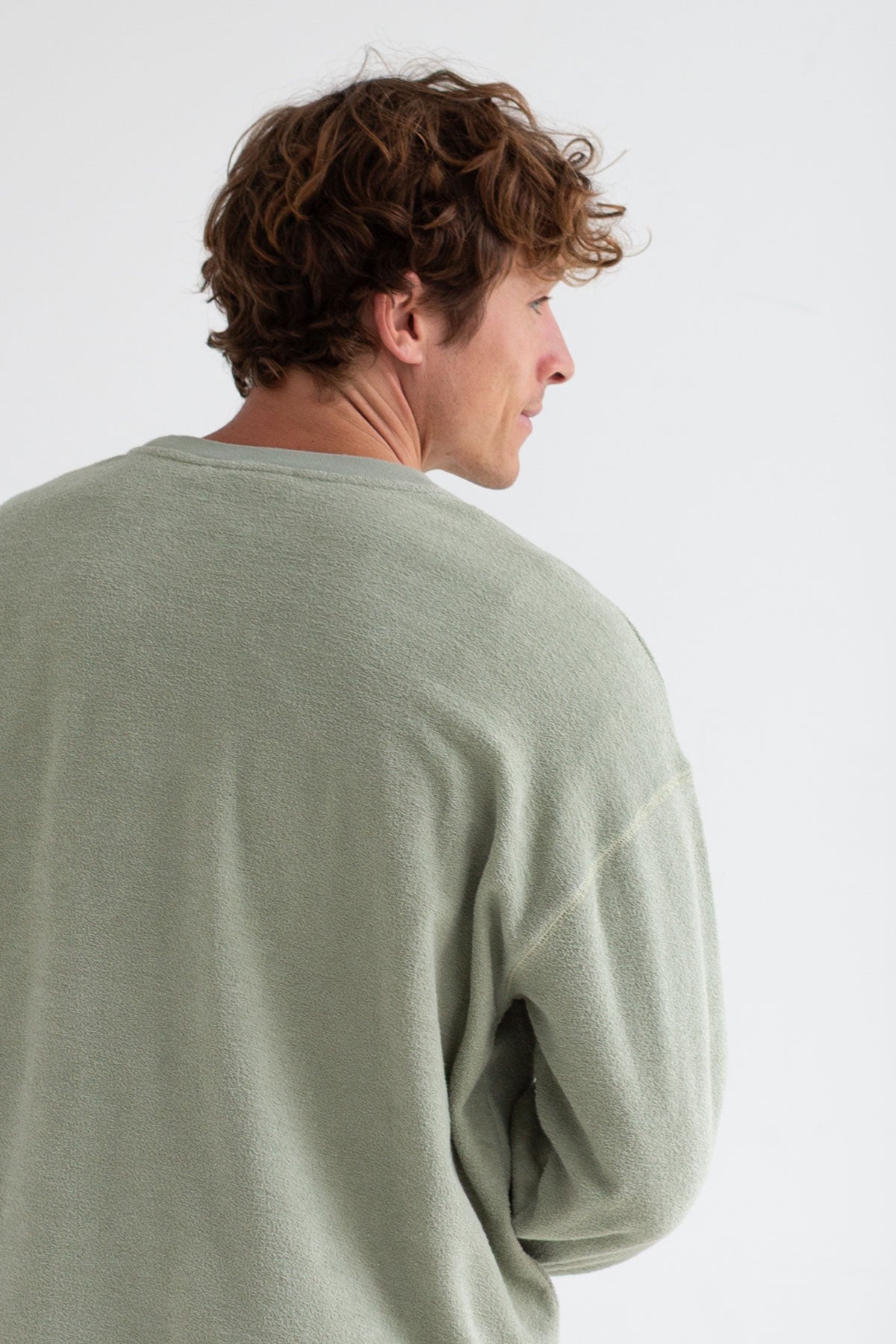 Light green sweatshirt men light pants full body view back