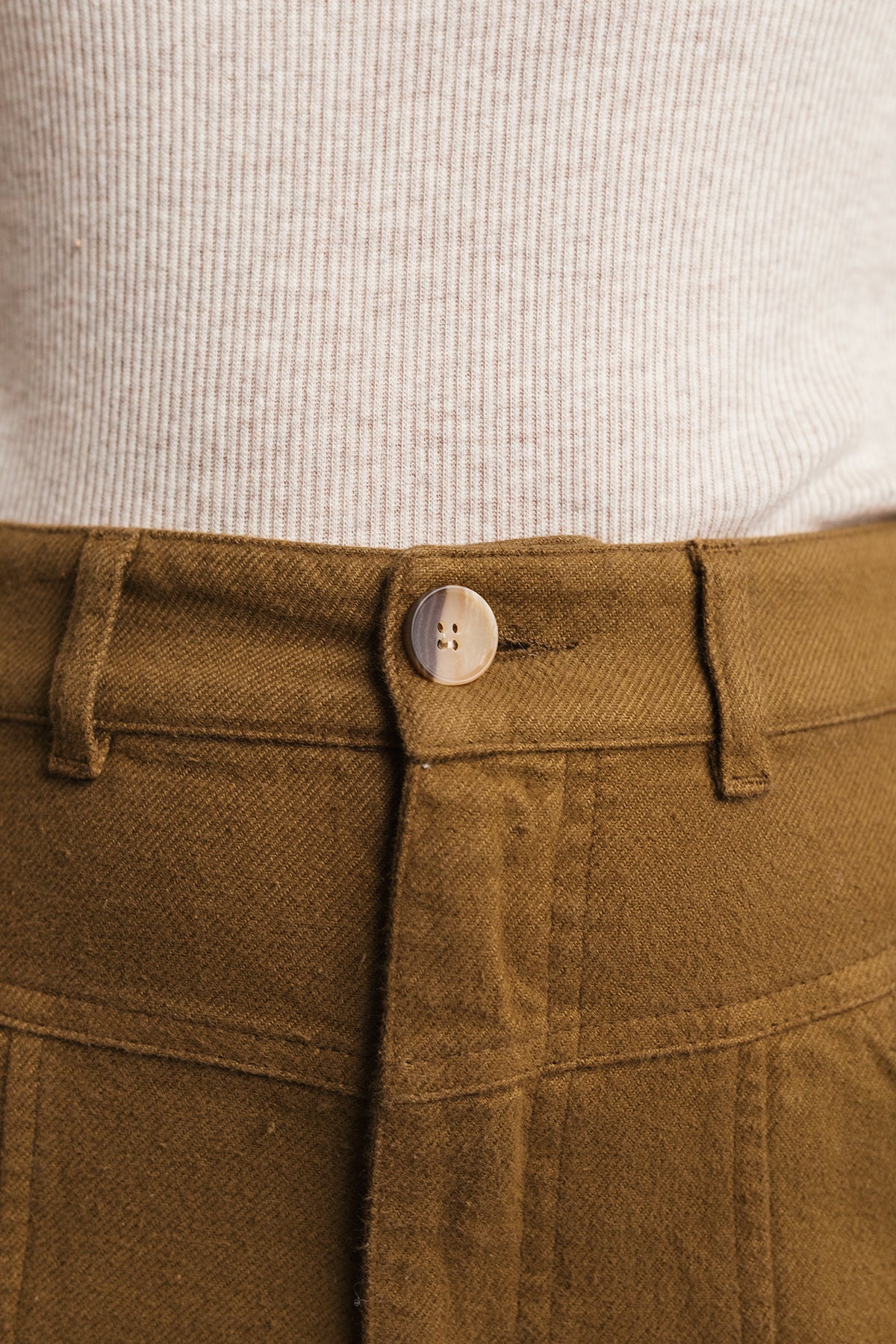 close-up of corozo button and organic waistband ochre pants.