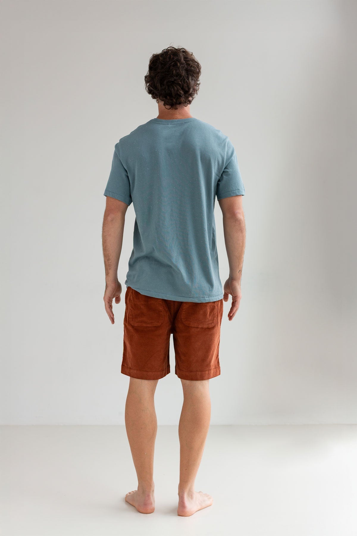 Old blue t-shirt men brown shorts full body view back