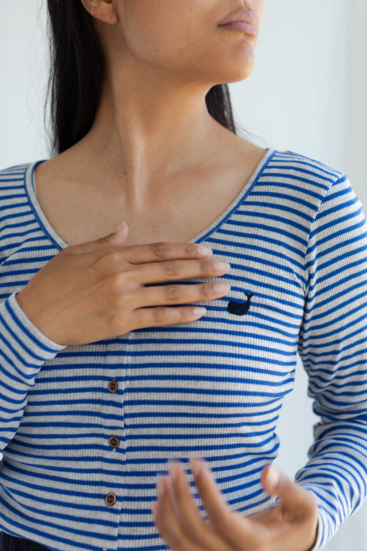 Close-up front view of a striped scoop neck top showing the embroidered whale logo.