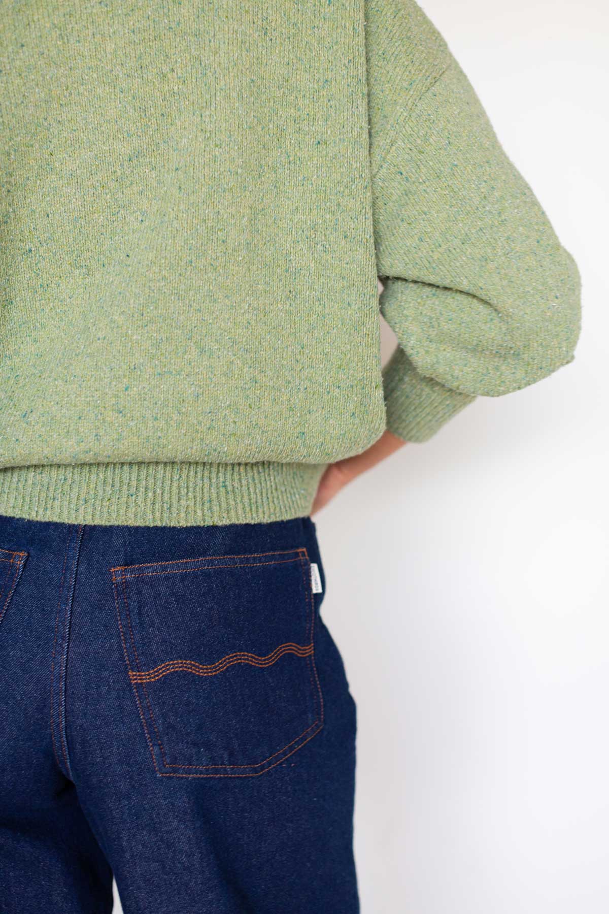 Back view detail showing the ribbed hem of a matcha green cropped polo sweater.