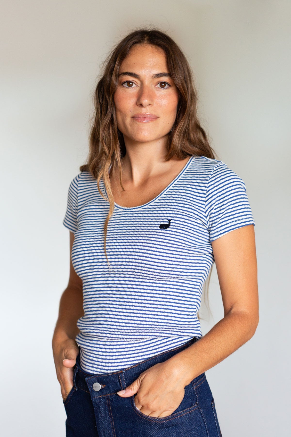 Woman wearing a faience blue striped slim-fit scoop neck ribbed top.