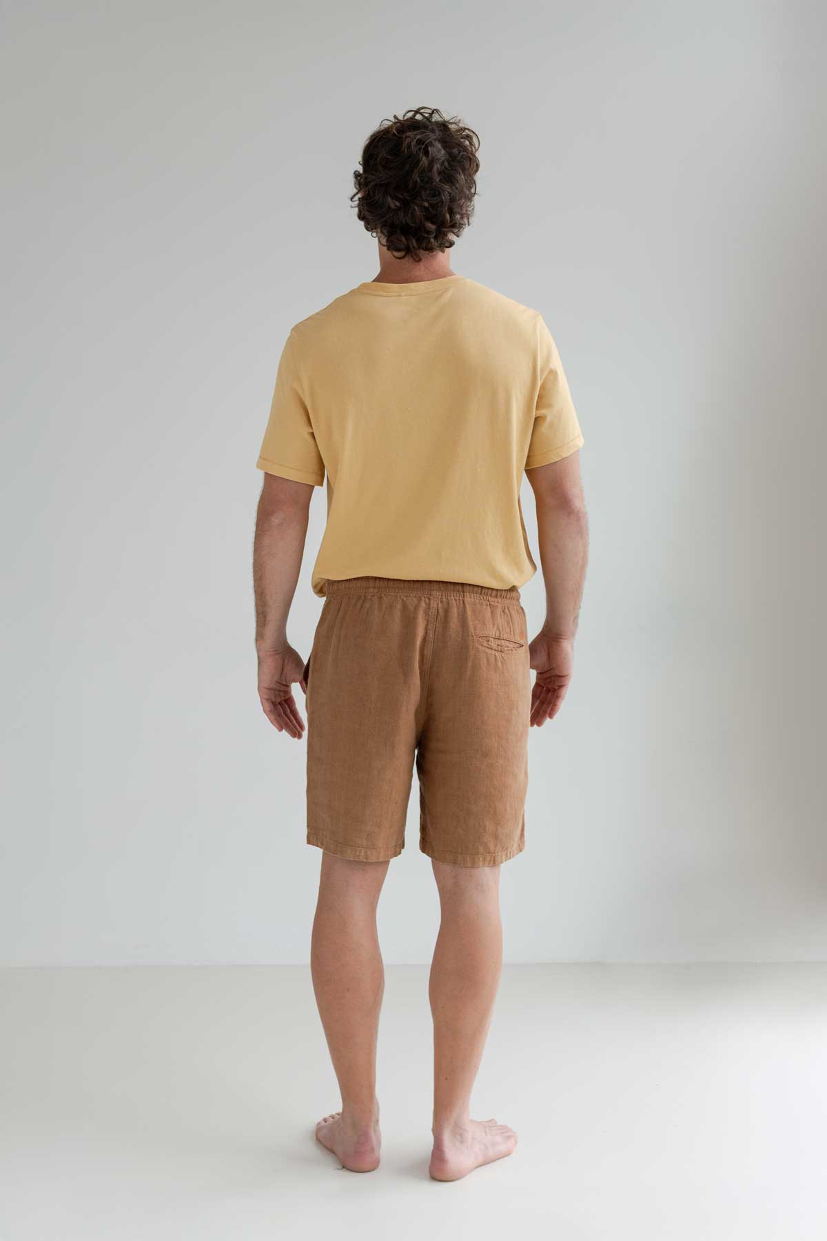Adobe heavy linen shorts men yellow tshirt full body view back
