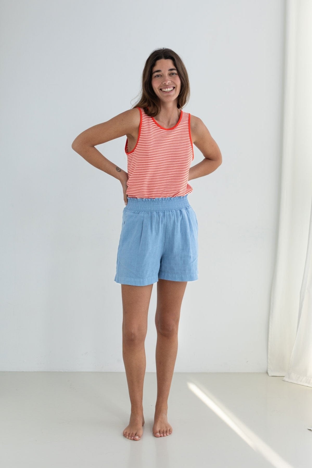 Bright red stripes lightweight vest top women light blue shorts full body view front