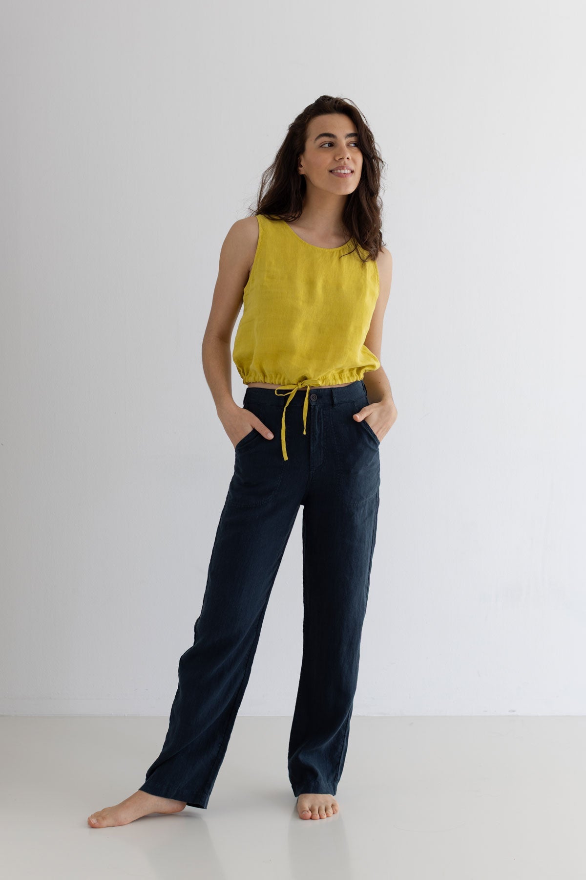 Golden green sleeveless linen shirt women navy pants full body view front 