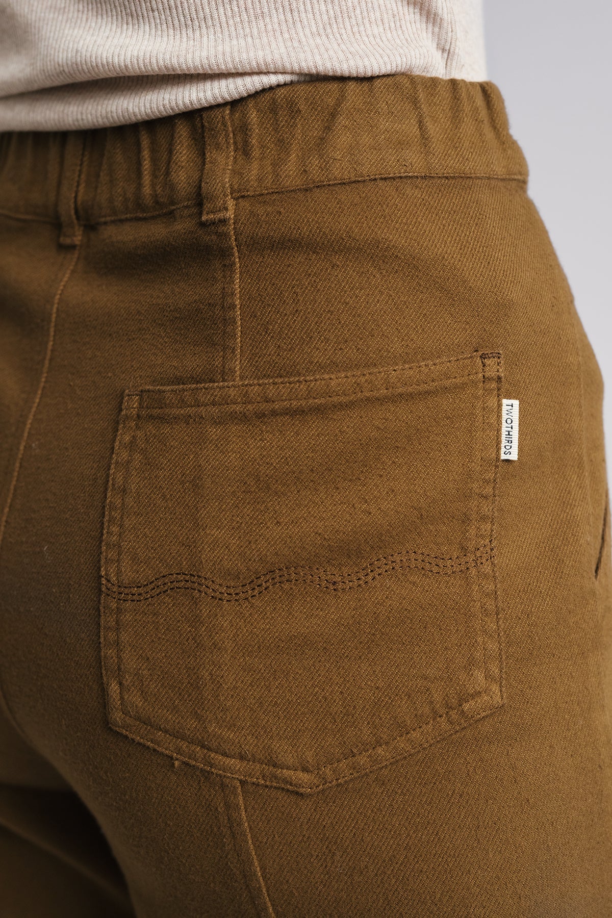 rear view of ochre flannel pants and back pocket design.