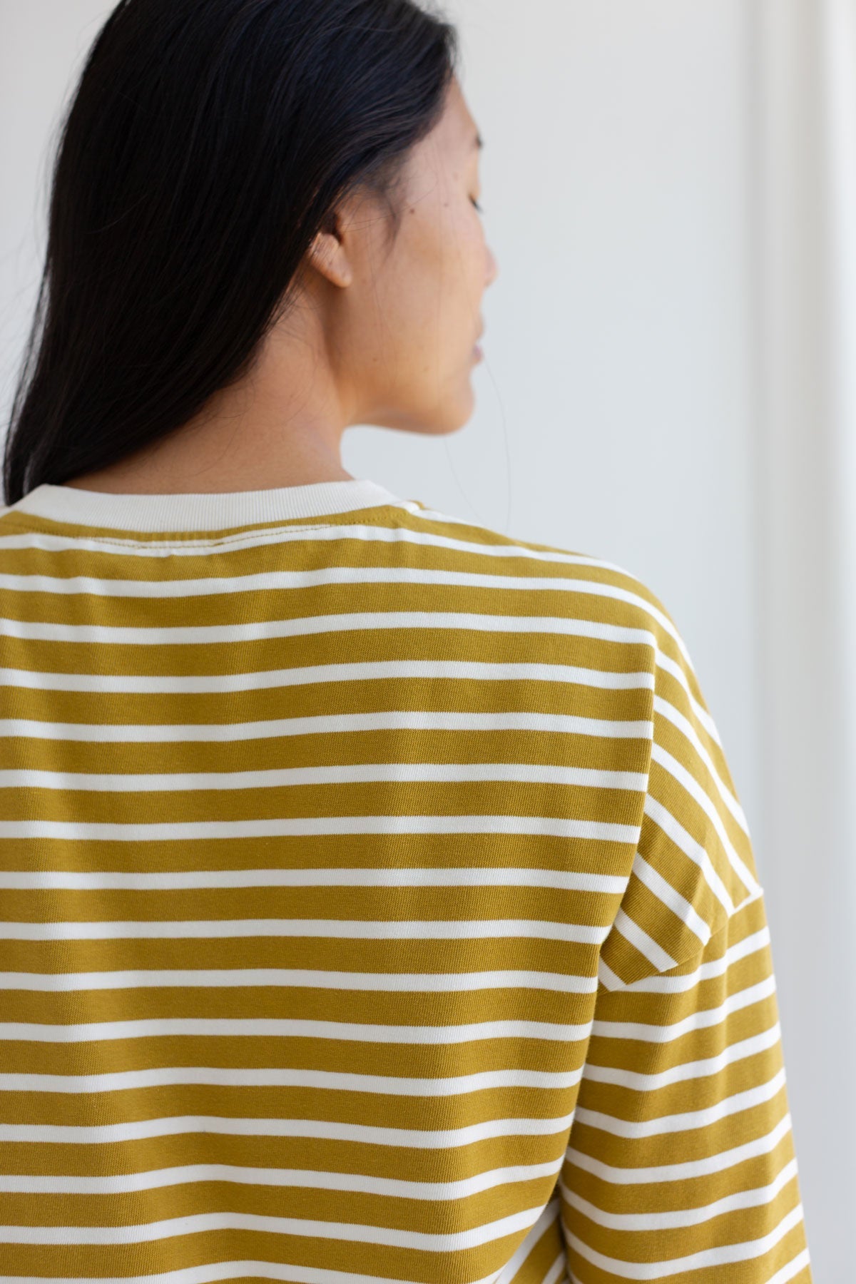 Back close-up view of a mustard yellow top.